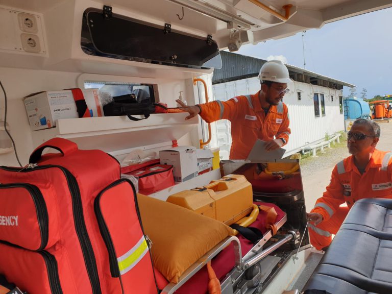 Global Health Assistance Staff checking equipment in an ambulance before deployment